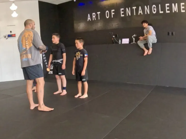 A family training Brazilian Jiu-Jitsu together on the mats at AOE