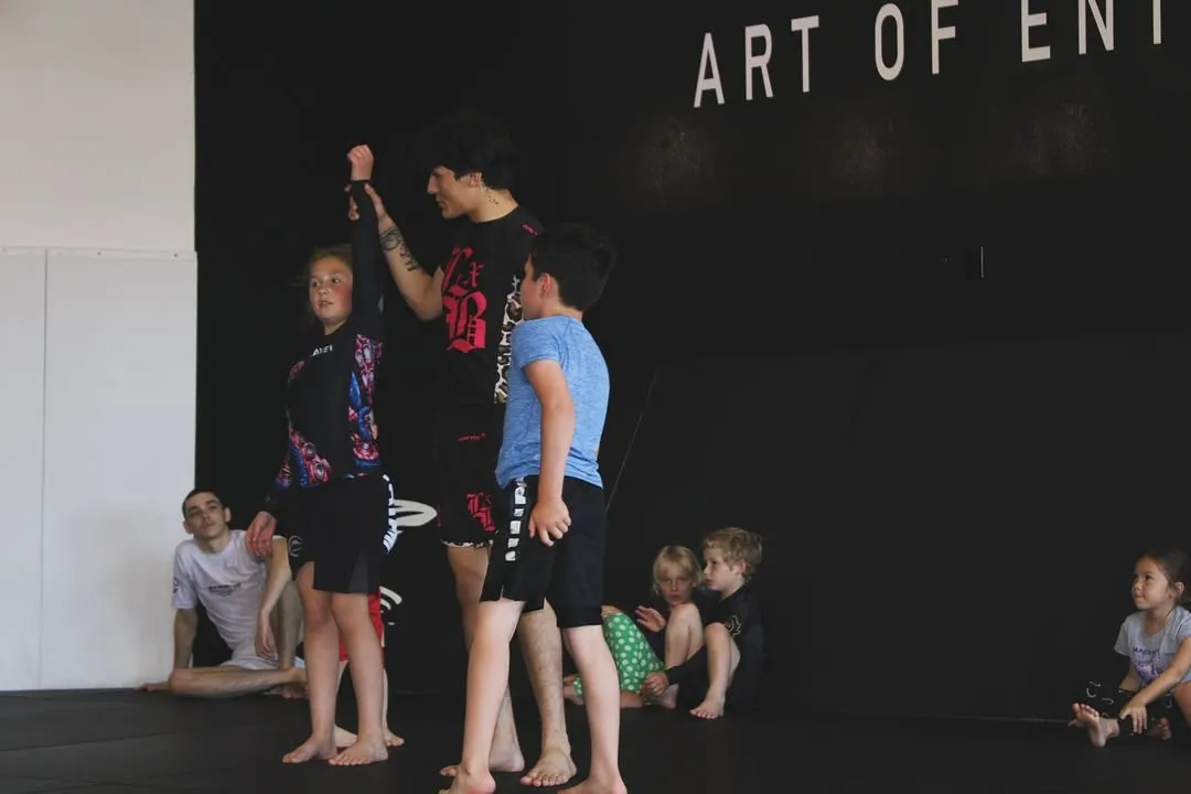 Kids learning self-defense through Brazilian Jiu-Jitsu in a class at AOE